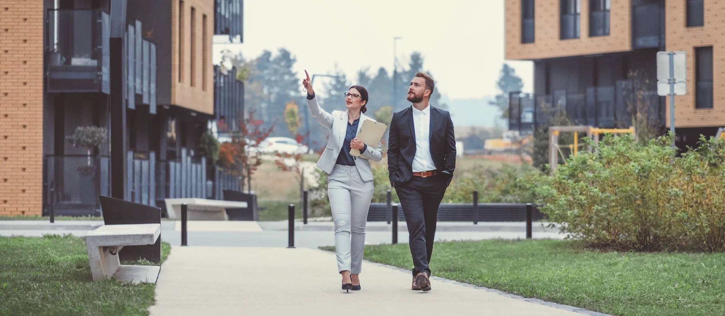 Real estate agents touring a modern property development, discussing opportunities in an urban neighborhood.