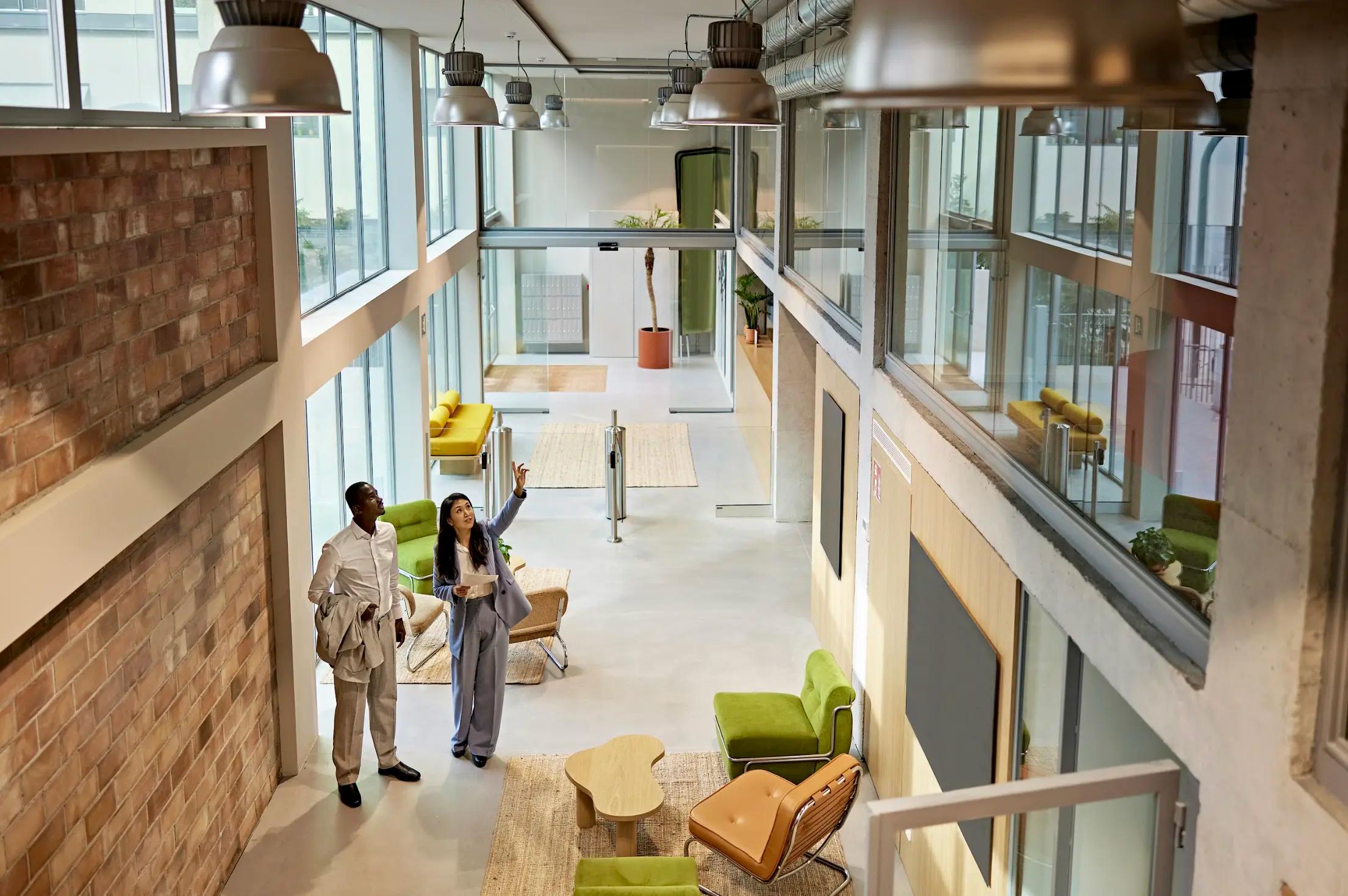 Professionals touring a stylish, open-concept commercial office space with natural light and modern decor.